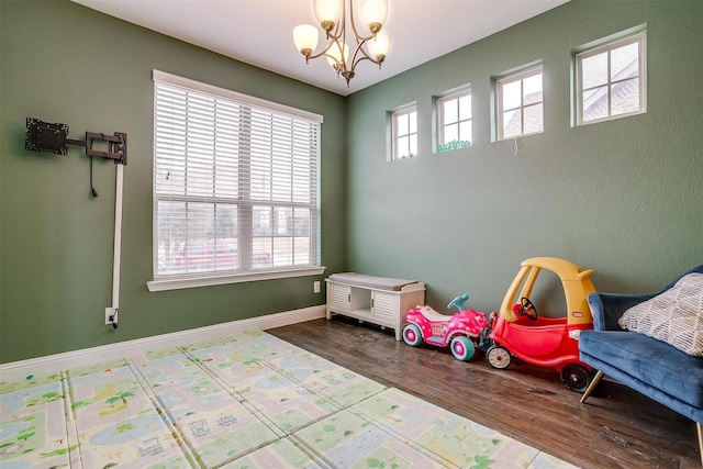 playroom with hardwood / wood-style flooring and a chandelier