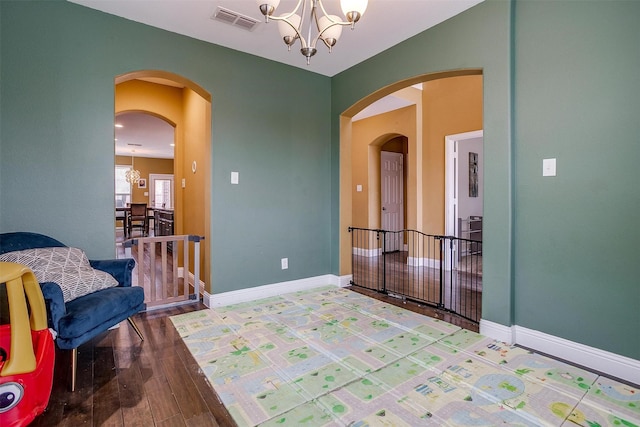 spare room with hardwood / wood-style flooring and an inviting chandelier