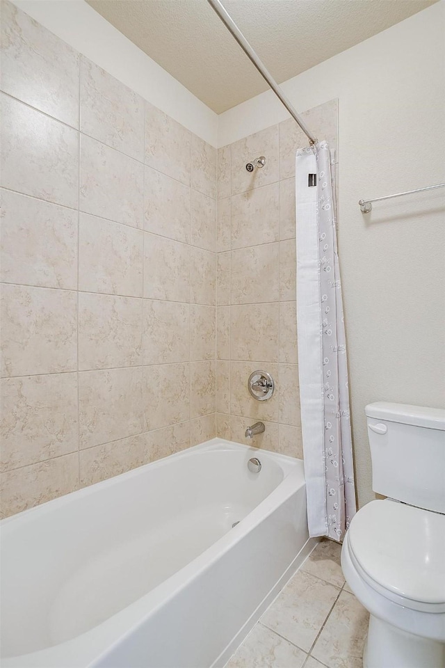 bathroom with toilet, shower / bath combo with shower curtain, and a textured ceiling