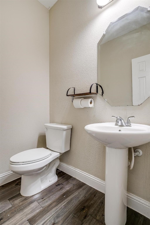 bathroom featuring sink, wood-type flooring, and toilet