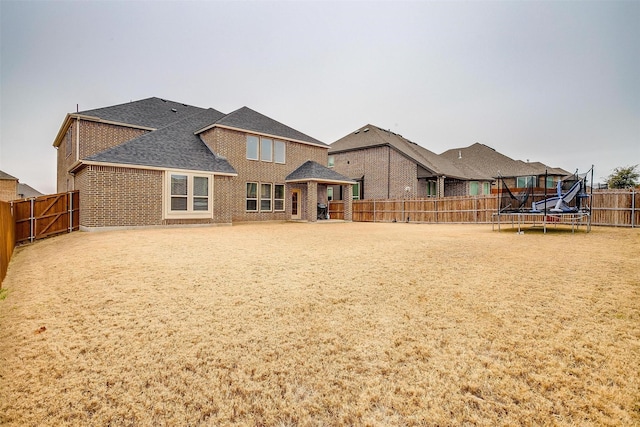 rear view of house featuring a trampoline