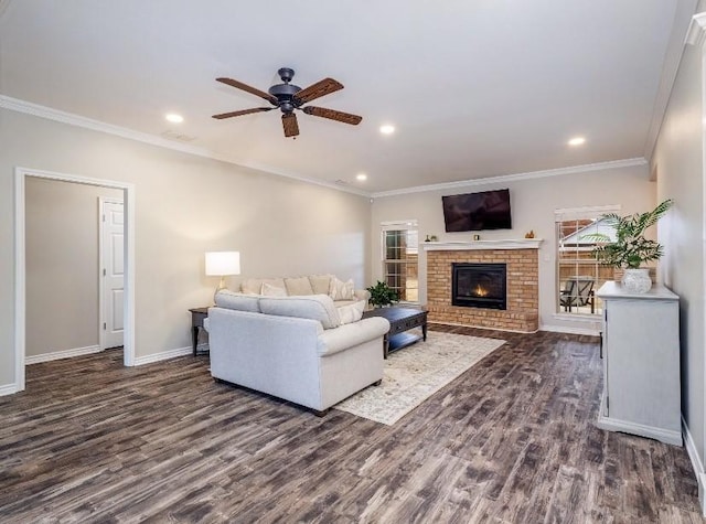 living room with a fireplace, ornamental molding, dark hardwood / wood-style floors, and ceiling fan