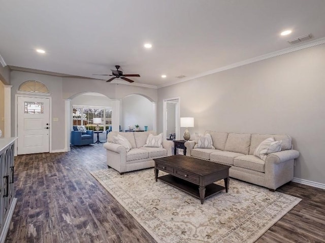 living room featuring ceiling fan, ornamental molding, and dark hardwood / wood-style flooring