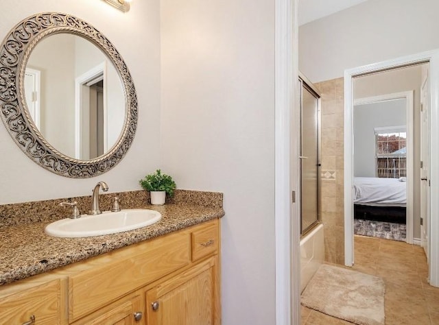 bathroom featuring vanity, tile patterned floors, and enclosed tub / shower combo