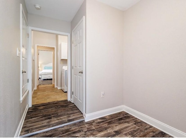 corridor featuring dark hardwood / wood-style flooring and washer / dryer