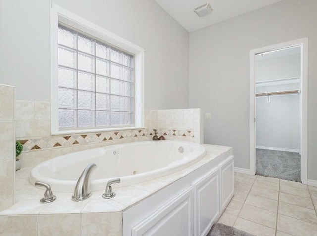 bathroom with tiled bath and tile patterned floors