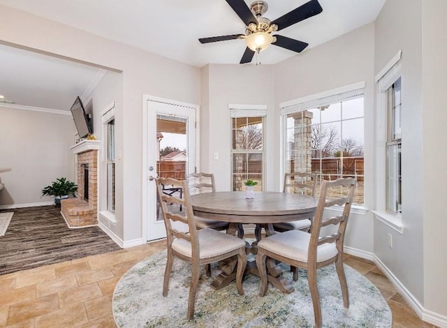 dining space featuring crown molding, a brick fireplace, and ceiling fan