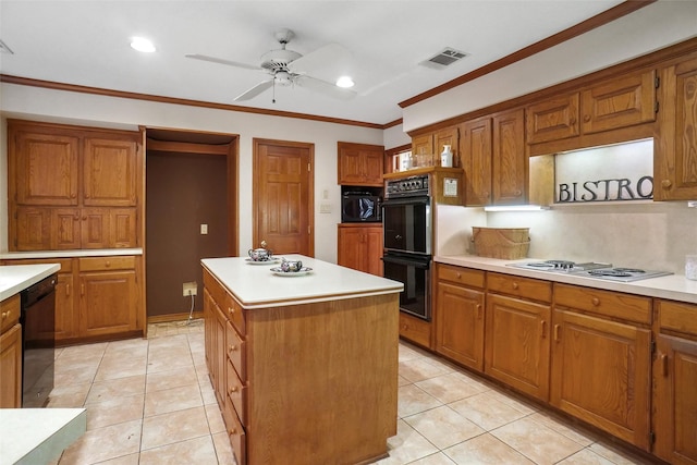 kitchen with ornamental molding, a center island, light tile patterned floors, and black appliances