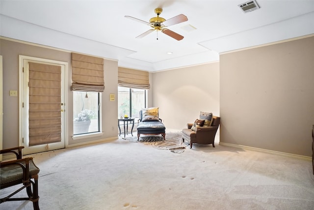 living area featuring crown molding, carpet floors, and ceiling fan