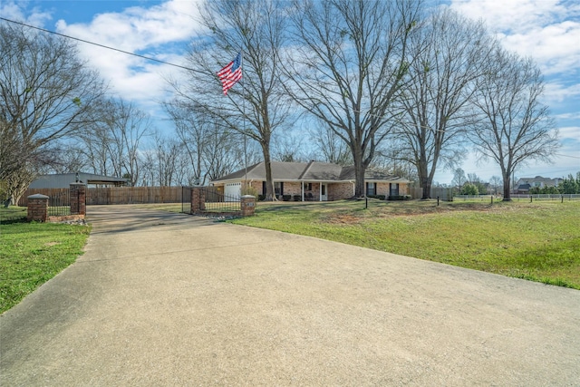 view of front of house with brick siding, a fenced front yard, concrete driveway, a front yard, and a garage