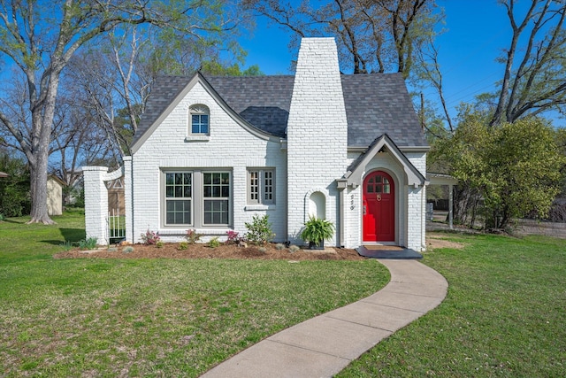 tudor home featuring a front lawn