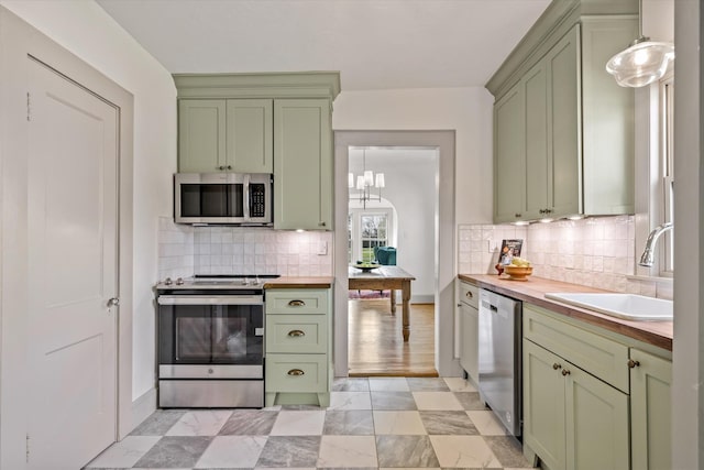 kitchen featuring wood counters, stainless steel appliances, green cabinets, and sink