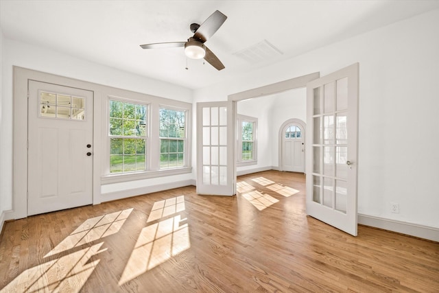 doorway with light hardwood / wood-style floors, french doors, and ceiling fan