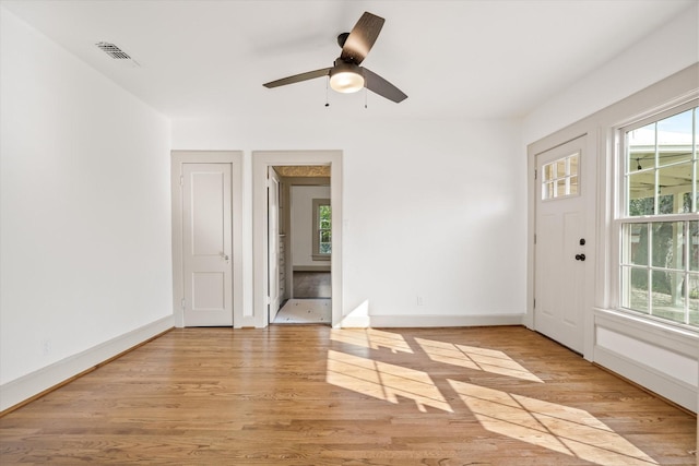 foyer entrance with ceiling fan and light wood-type flooring