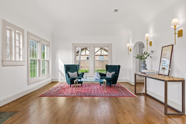 living area with wood-type flooring and vaulted ceiling