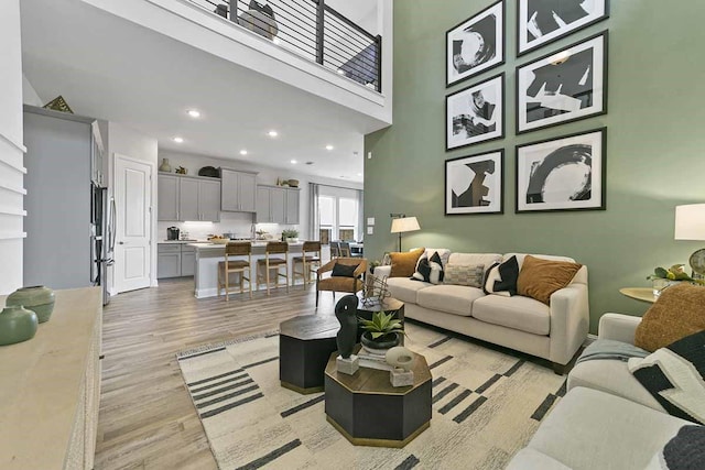 living room with light hardwood / wood-style flooring and a high ceiling