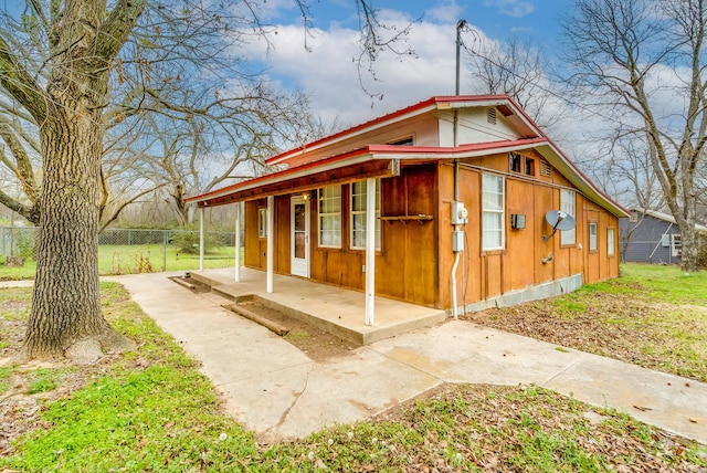 exterior space featuring a porch and fence