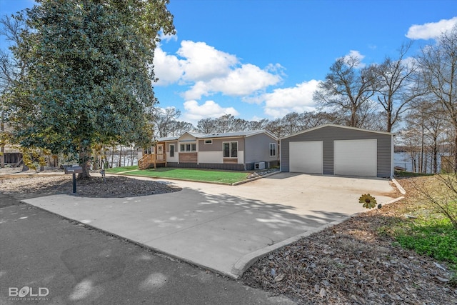 single story home featuring an outbuilding, a garage, and a front yard