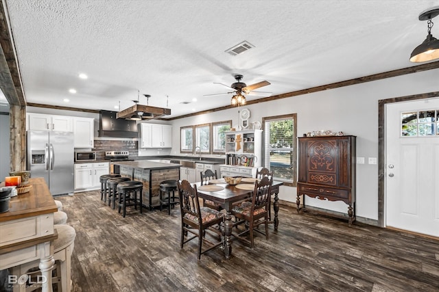 dining area featuring ornamental molding, ceiling fan, a textured ceiling, and dark hardwood / wood-style flooring