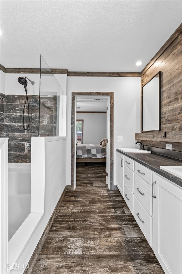 bathroom featuring vanity, wood-type flooring, a textured ceiling, and walk in shower