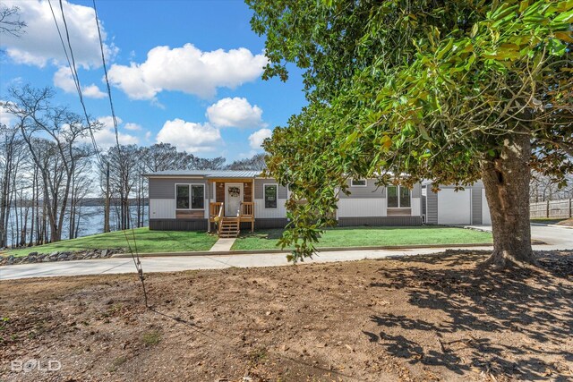 view of front of home featuring a water view and a front lawn