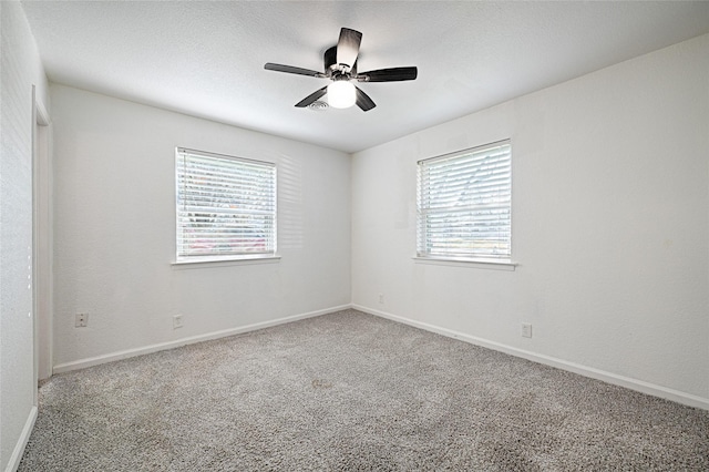 carpeted spare room featuring ceiling fan, a textured ceiling, and baseboards