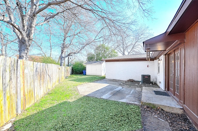 view of yard featuring a patio area, a fenced backyard, a storage unit, and an outdoor structure