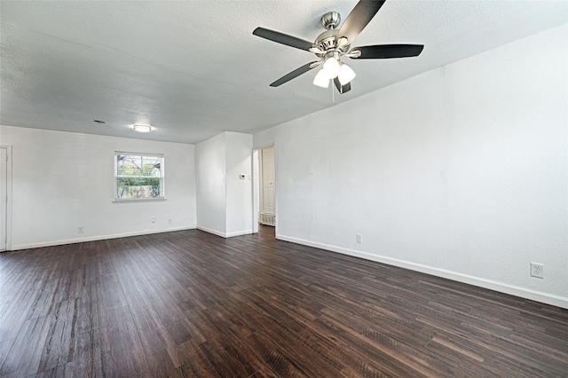 empty room featuring a ceiling fan, baseboards, dark wood finished floors, and a textured ceiling