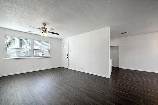 spare room featuring a ceiling fan, a textured ceiling, baseboards, and dark wood-style flooring