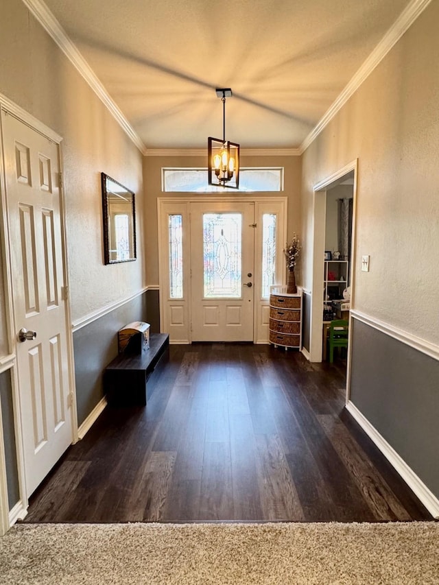 foyer with crown molding, dark hardwood / wood-style floors, and an inviting chandelier