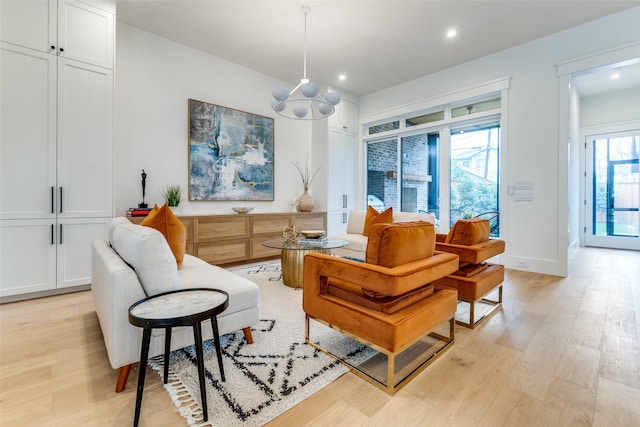 living area featuring a chandelier and light hardwood / wood-style floors