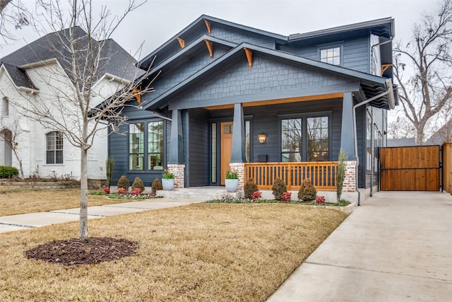 craftsman-style home with a front yard and covered porch