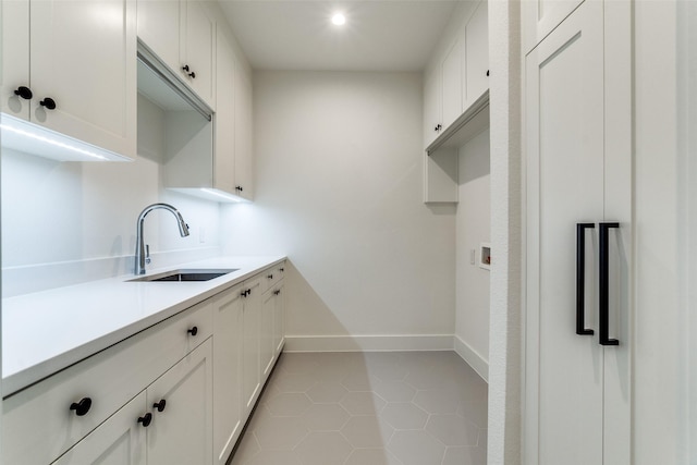 kitchen featuring white cabinetry, light tile patterned flooring, and sink