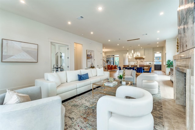 living room with a stone fireplace and a healthy amount of sunlight