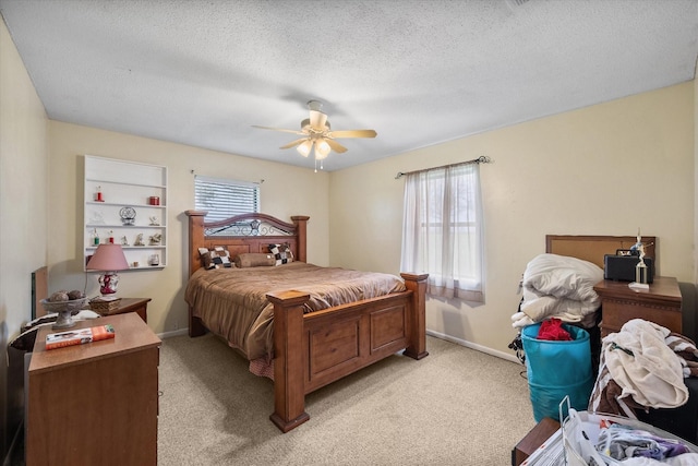 carpeted bedroom featuring ceiling fan and a textured ceiling