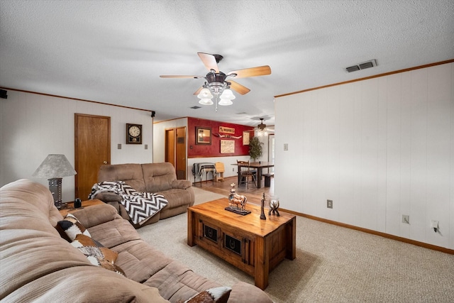 living room with ornamental molding, light colored carpet, and a textured ceiling