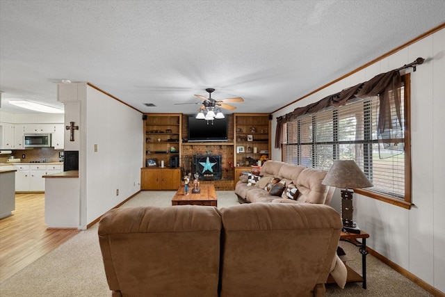 living room with a brick fireplace, crown molding, a textured ceiling, and ceiling fan