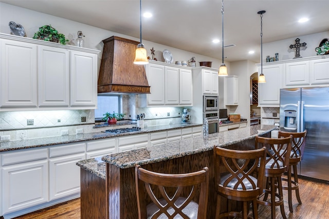 401 Devonshire Dr, Prosper, TX 75078 - kitchen with stainless steel appliances, custom range hood, white cabinetry, a kitchen bar, and recessed lighting