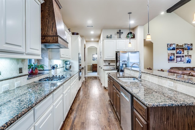 401 Devonshire Dr, Prosper, TX 75078 - kitchen with a sink, stainless steel appliances, premium range hood, arched walkways, and dark wood-style flooring