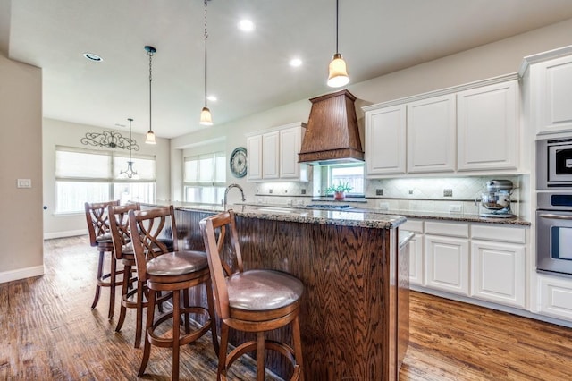 401 Devonshire Dr, Prosper, TX 75078 - kitchen featuring appliances with stainless steel finishes, wood finished floors, white cabinetry, and recessed lighting