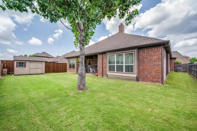 401 Devonshire Dr, Prosper, TX 75078 - back of property with brick siding, a chimney, a fenced backyard, a storage unit, and a shingled roof
