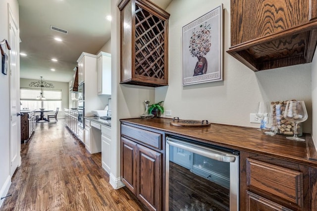 401 Devonshire Dr, Prosper, TX 75078 - indoor dry bar with wine cooler, dark wood-style floors, recessed lighting, and stainless steel oven