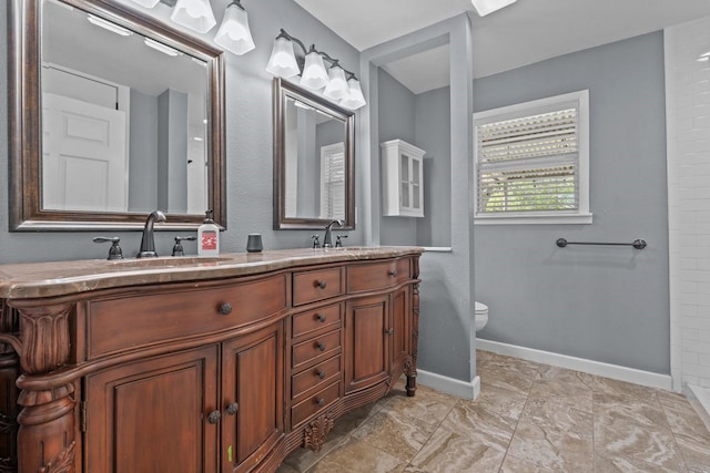 119 Wheeler St, Weatherford, TX 76086 - bathroom featuring baseboards, a sink, double vanity, and toilet