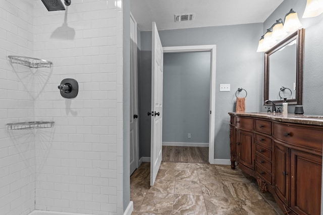 119 Wheeler St, Weatherford, TX 76086 - bathroom featuring visible vents, baseboards, a tile shower, vanity, and marble finish floor