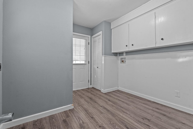 119 Wheeler St, Weatherford, TX 76086 - clothes washing area featuring wood finished floors, washer hookup, baseboards, and cabinet space