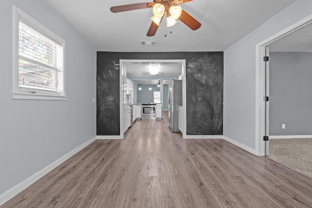 119 Wheeler St, Weatherford, TX 76086 - unfurnished living room featuring visible vents, baseboards, a ceiling fan, and light wood finished floors