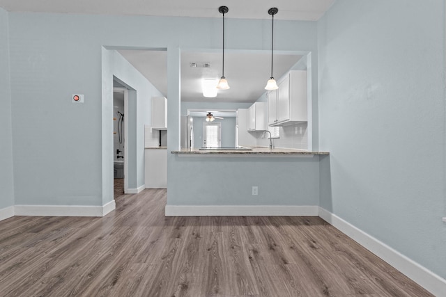 119 Wheeler St, Weatherford, TX 76086 - kitchen with a ceiling fan, wood finished floors, a sink, and white cabinetry