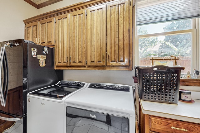 clothes washing area with independent washer and dryer and cabinets