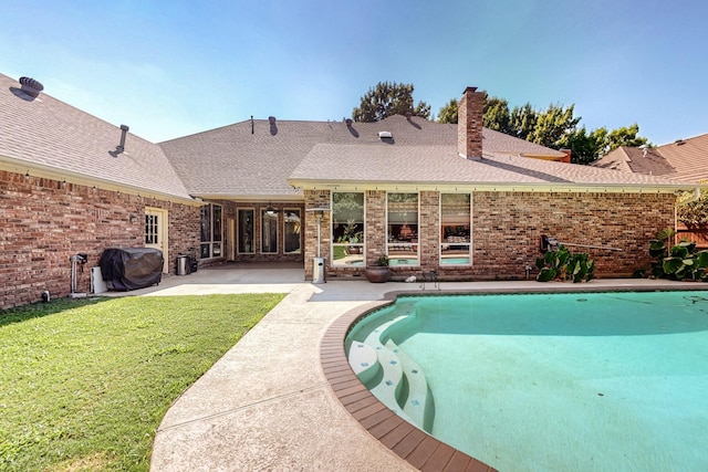 view of pool with area for grilling, a yard, and a patio area