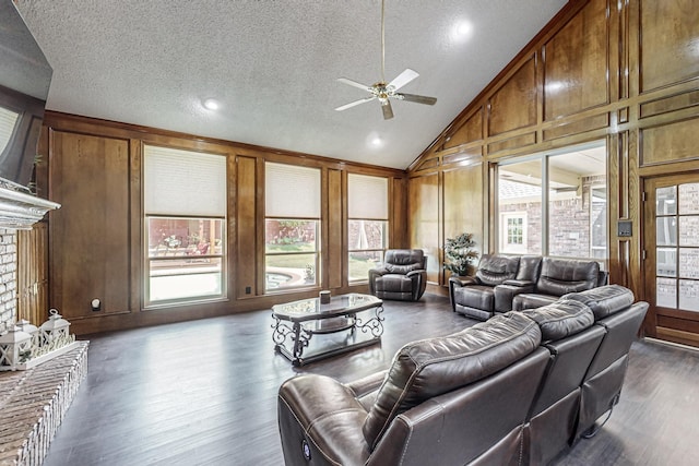 living room with dark hardwood / wood-style flooring, a wealth of natural light, a brick fireplace, and wood walls